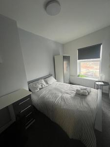 a white bedroom with a bed and a window at Luxury in luxury out in Nottingham