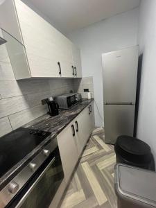a kitchen with a sink and a refrigerator at Luxury in luxury out in Nottingham