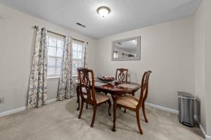 a dining room with a table and chairs and a window at Comfortable Greensboro Condo in Greensboro