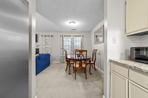 a kitchen and dining room with a table and chairs at Comfortable Greensboro Condo in Greensboro