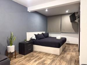 una camera con un grande letto e un armadio nero di Dpto. moderno zona boulevard a Morelia