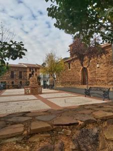 een parkbankje voor een bakstenen gebouw bij ALOJAMIENTO TURISTICO LAS SOLANERAS in Solana del Pino