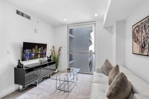 uma sala de estar branca com um sofá e uma televisão em Prime Location 1-Bed Retreat With Free Parking em Miami