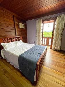 una camera da letto con un letto grande con una parete in legno di Angra dos Sonhos ad Angra dos Reis