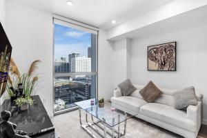 uma sala de estar com um sofá branco e uma mesa de vidro em Prime Location 1-Bed Retreat With Free Parking em Miami
