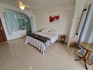 a bedroom with a bed and a table and a window at HOTEL DAIFA in Florianópolis