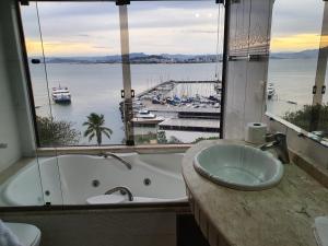 a bathroom with a tub and a view of a harbor at HOTEL DAIFA in Florianópolis