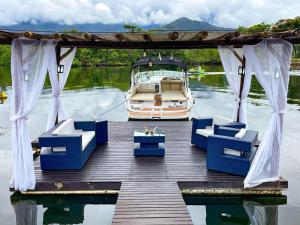 Ein Boot steht auf einem Dock mit blauen Stühlen. in der Unterkunft Angra dos Sonhos in Angra dos Reis