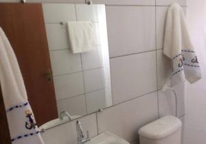 a bathroom with a toilet and a sink and a mirror at Chalé Mirante do Vale in Piatã