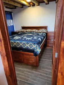 een slaapkamer met een houten bed in een kamer bij Casa 89 in Nabón