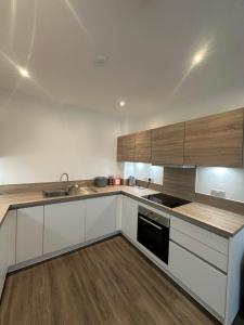 a kitchen with white counters and wooden cabinets at C U Property Ltd in Manchester