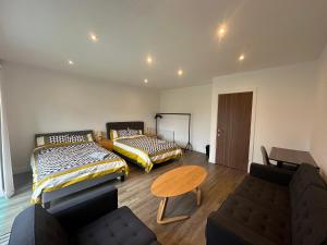 a room with two beds and a table and a couch at C U Property Ltd in Manchester