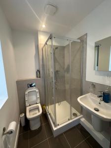 a bathroom with a shower and a toilet and a sink at C U Property Ltd in Manchester