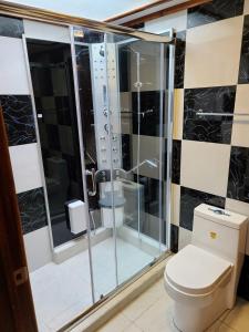 een badkamer met een douche en een toilet bij Casa 89 in Nabón