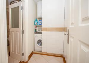 uma lavandaria branca com máquina de lavar e secar roupa em Stone Pearl Heritage Luxury Suite em Split mais 20 fotografias