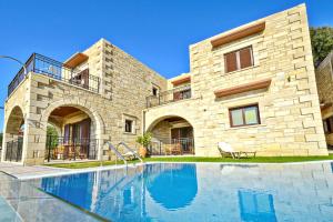 une maison avec une piscine en face d'un bâtiment dans l'établissement Fotini Traditional Villas, à Kavoúsion