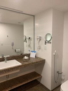 La salle de bains est pourvue d'un lavabo et d'un miroir. dans l'établissement Pirâmide palace resort, à Natal