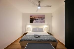 a bedroom with a bed with a painting on the wall at HolaOla HighClass Townhouse in Lajares +27 photos