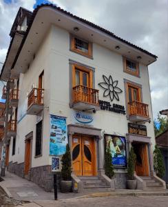 Ein weißes Gebäude mit einer Blume darauf. in der Unterkunft Illari Wari II-Hotel Sauna in Ayacucho