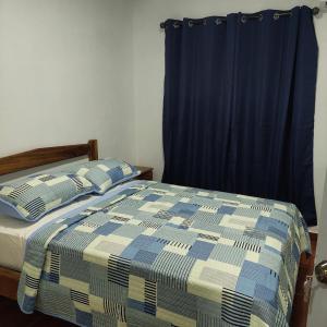 a bedroom with a bed with a blue curtain at Casa de playa in Isla Grande
