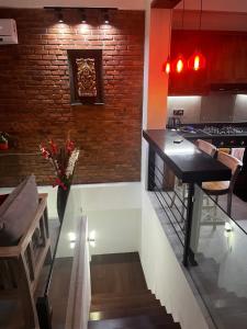 a kitchen with a black counter and a brick wall at Sai Sruthi Residences in Colombo