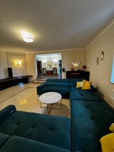 un soggiorno con divano blu e tavolo di Premium Residence SPA & Garden a Glińcz