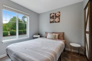 a white bedroom with a large bed and a window at Pet Friendly and Spacious Valley View Family Home in Snohomish