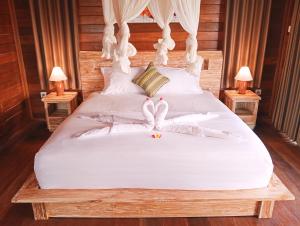 Un dormitorio con una cama con dos cisnes. en Umedevasya, en Sidemen