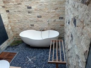 y baño con bañera blanca en una pared de piedra. en Umedevasya, en Sidemen