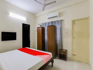 a bedroom with a bed and a tv in it at OYO KAILAYA GUDIL RESIDENCY in Chennai