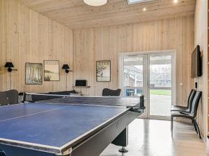 a ping pong table in a room with wooden walls at 18 person holiday home in Idestrup in Marielyst