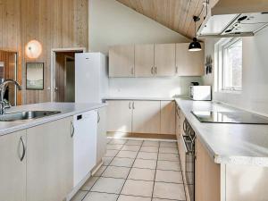 - une cuisine avec des placards blancs et un évier dans l'établissement 18 person holiday home in Idestrup, à Bøtø By