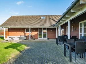 une terrasse avec des tables et des chaises dans une maison dans l'établissement 18 person holiday home in Idestrup, à Bøtø By