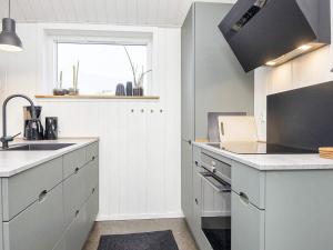een keuken met witte kasten, een wastafel en een raam bij 10 person holiday home in Harbo re in Harboør