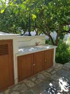 a kitchen with wooden cabinets in front of a tree at casa cocos in San Vito lo Capo +4 photos