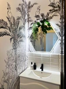 カイエンヌにあるL'Ecrin Boisé-Studio de Prestigeの洗面台と鏡のあるバスルーム