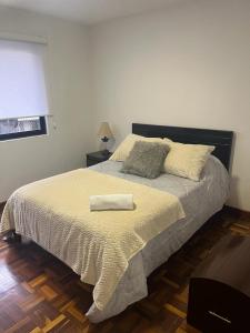 a bedroom with a bed with a towel on it at DEPARTAMENTO DUPLEX 3 Habitaciones EN CUENCA ECUADOR in Cuenca