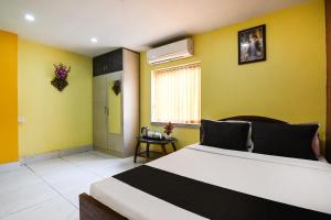 a bedroom with a large bed with yellow walls at OYO Royal Crown Banquet in Kolkata