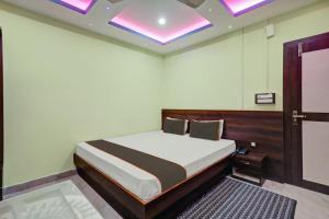 a bedroom with a bed and a ceiling with lights at OYO Flagship Hotel Maa Bharati in Guwahati