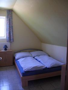 a bedroom with a bed with blue sheets and a window at Ferienhaus Hartmann in Hévíz