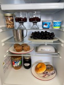 a refrigerator filled with lots of different types of food at Lakeview Gardens B&B in Peachland