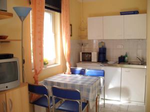 a kitchen with a table and chairs and a table and a television at Ferienhaus Hartmann in Hévíz