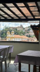 uma vista para uma cidade a partir de uma janela com mesas em Hostel e Pousada Mineira em Ouro Preto
