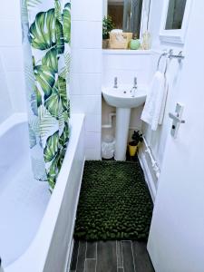 倫敦的住宿－1 bedroom flat London，一间带水槽和绿色地板的浴室