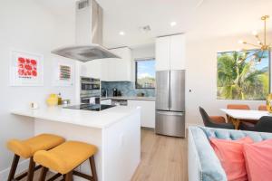 Silver Reef 2 Oceanfront Condo في North Side: مطبخ وغرفة معيشة مع دواليب بيضاء وطاولة وكراسي