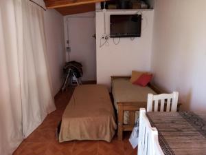 a room with two beds and a tv on the wall at Hospedaje San Mayol 