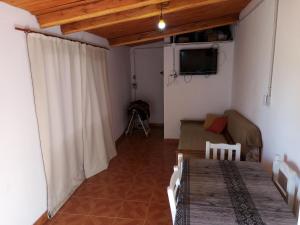 a room with a table and a couch and a television at Hospedaje San Mayol 