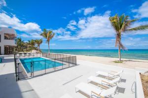 a villa with a swimming pool next to the beach at Silver Reef 2 Oceanfront Condo in North Side