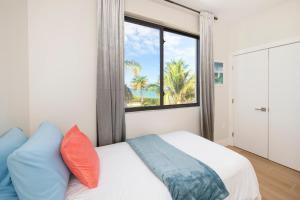 sypialnia z łóżkiem i oknem z palmami w obiekcie Silver Reef 2 Oceanfront Condo w mieście North Side