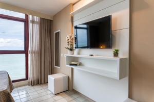 una habitación de hotel con TV en la pared en Golden Beach Flat Recife, en Recife